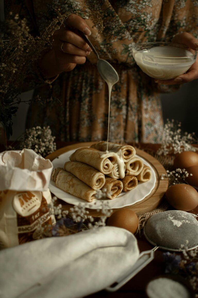 A plate of traditional Russian blini with a sweet sauce, perfect for dessert lovers.